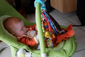 Le transat c'est sympa, j'ai des jouets et des étiquettes sur mes jouets sur lesquelles je m'attarde